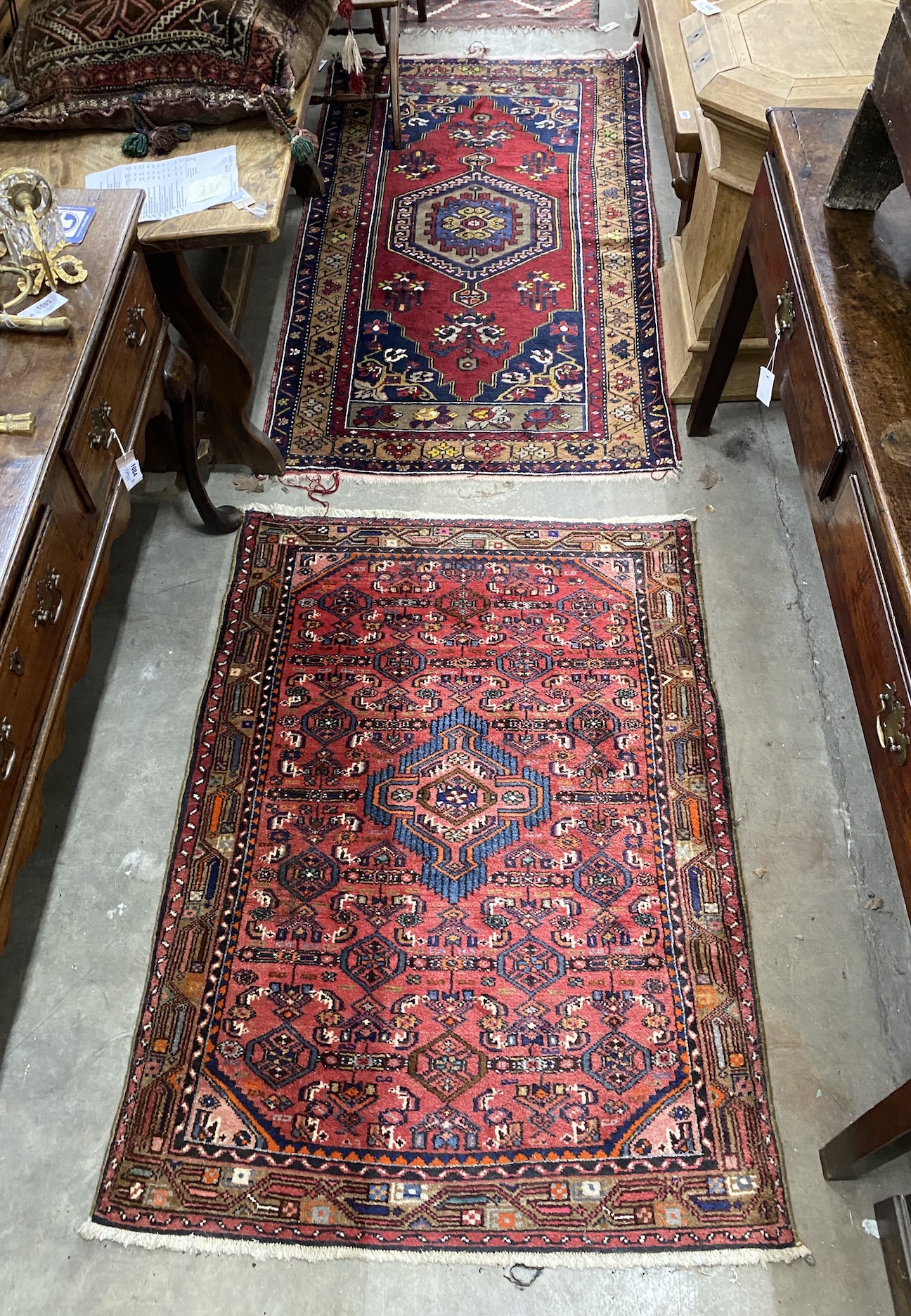 A Caucasian style burgundy ground rug and a North West Persian red ground rug, larger 194 x 106cm
